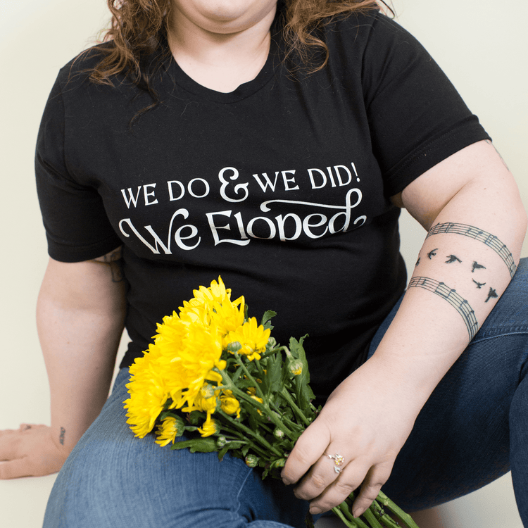 Black And White 'We Do, and We Did! We Eloped’ – Tee by Oaklynn Lane - Girl holding flowers with Black Tee