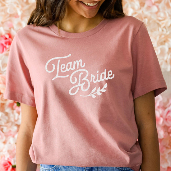 Bride squad beach bachelorette party with mauve and pink bride squad shirts